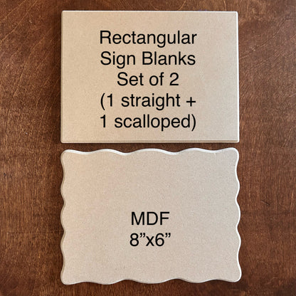 Two rectangular MDF sign blanks on a wooden surface, one straight and one scalloped.