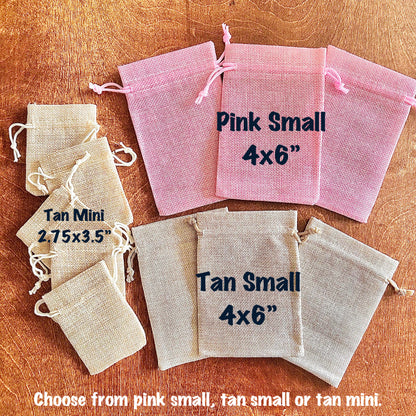 Set of small drawstring bags in pink and tan on a wooden surface with text indicating size and color.