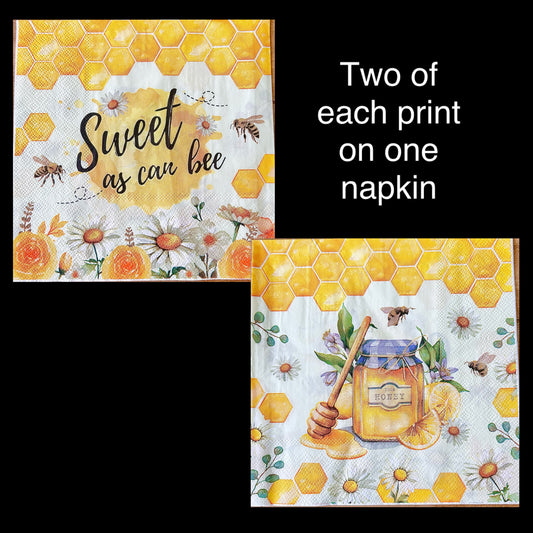 Two honey-themed napkins with bee and floral designs on a black background.