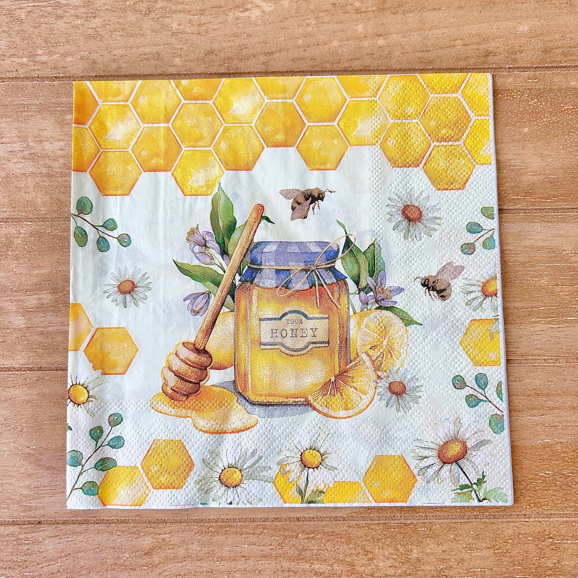 Decorative paper napkin with honey design on a wooden surface