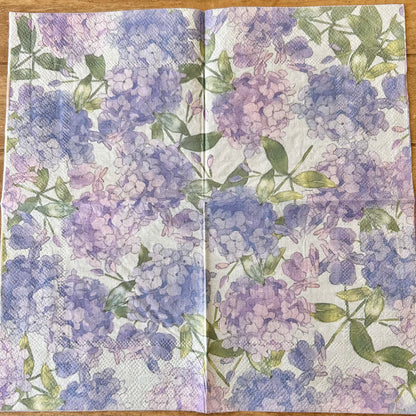 Floral patterned napkin with purple and green flowers on a wooden surface