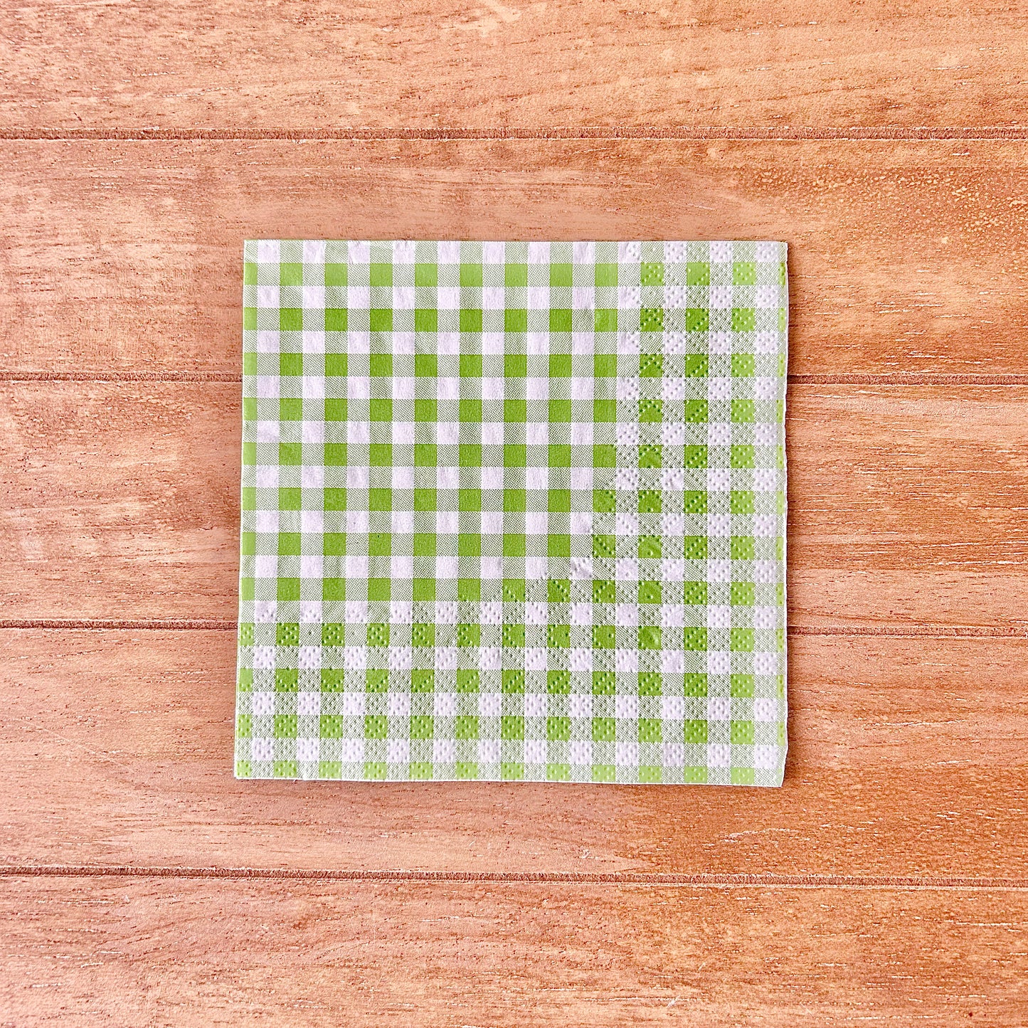 Green and white checkered gingham on a wooden surface