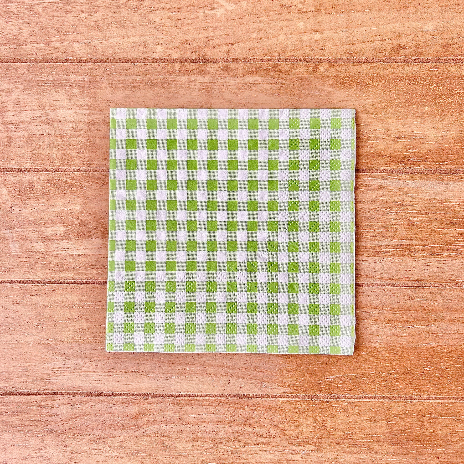 Green and white checkered gingham on a wooden surface