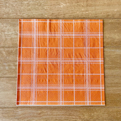 Plaid fabric with orange and white pattern on a wooden surface
