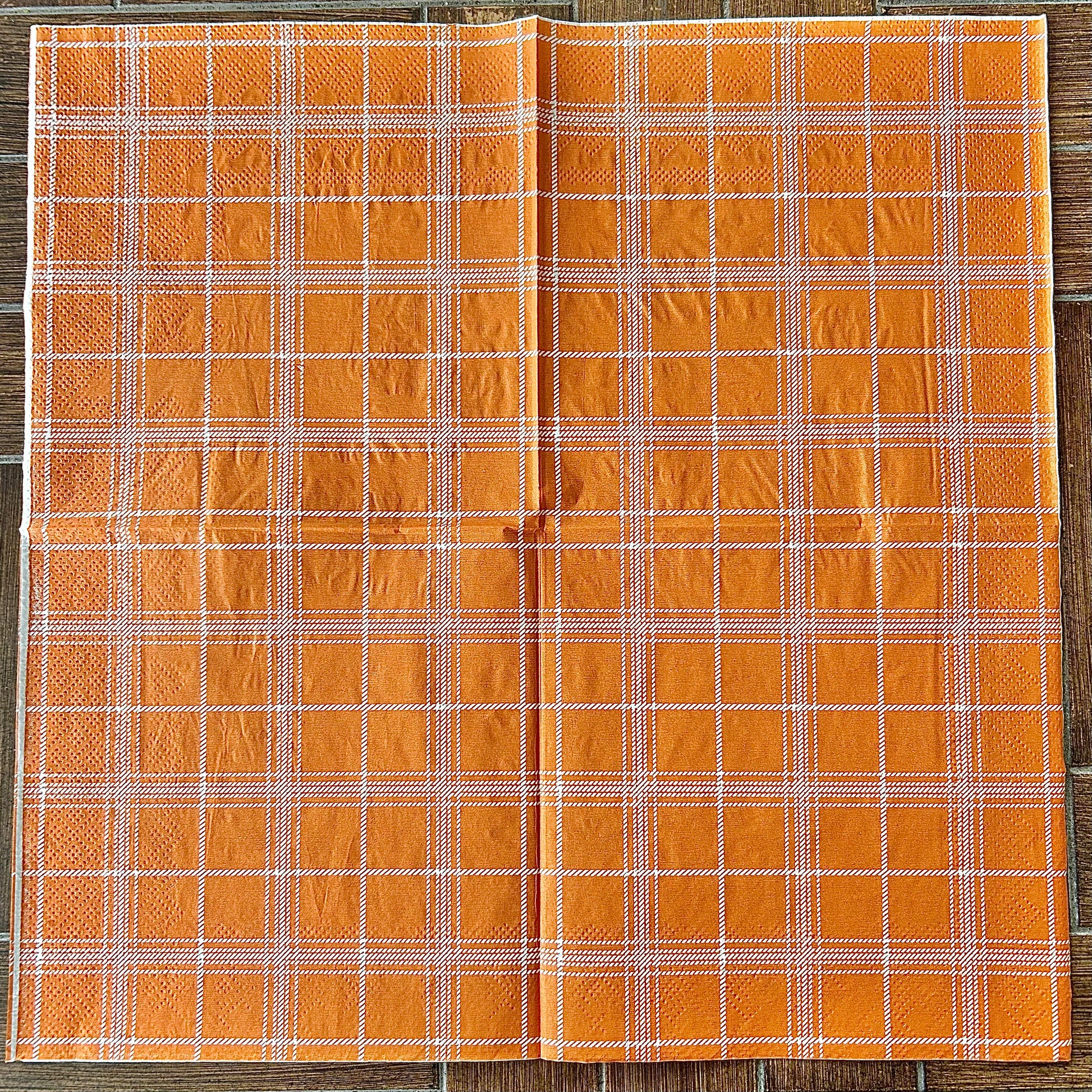 Orange plaid fabric on a wooden background