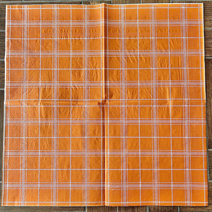 Orange plaid fabric on a wooden background