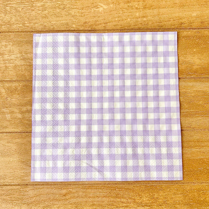 Purple and white checkered napkin on a wooden surface