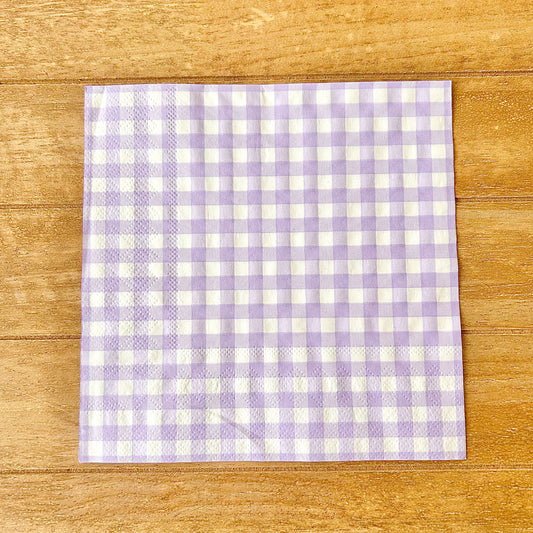 Purple and white checkered napkin on a wooden surface