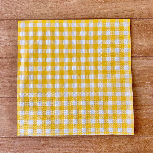 Yellow and white checkered napkin on a wooden surface