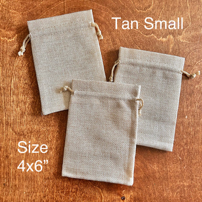 Three tan fabric drawstring bags on a wooden surface with text indicating size and color.