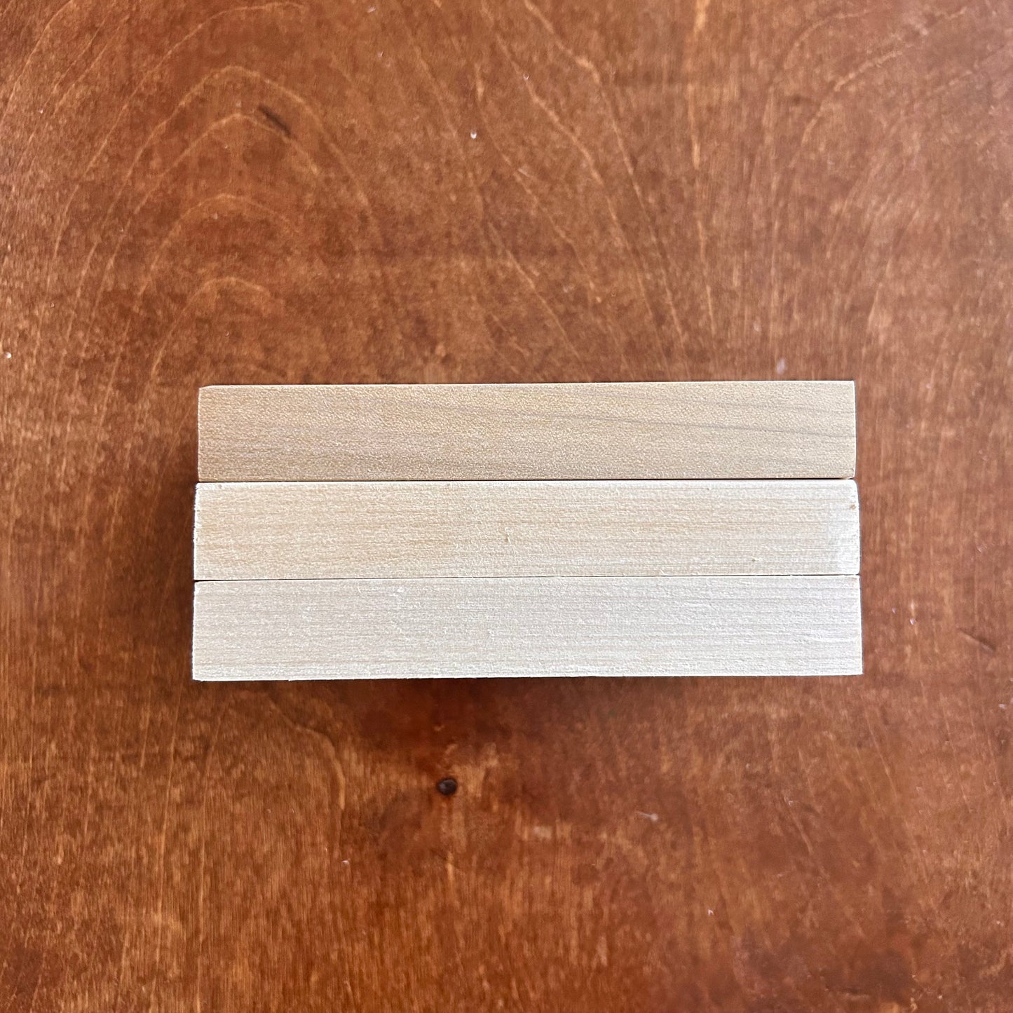 Set of wooden strips in various shades on a wooden surface